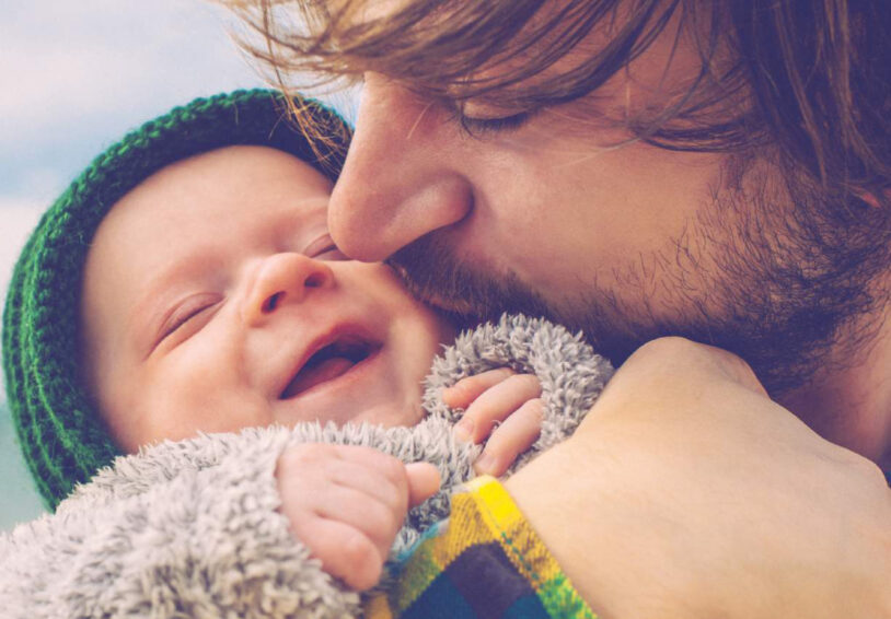 Vader die lachende baby knuffelt