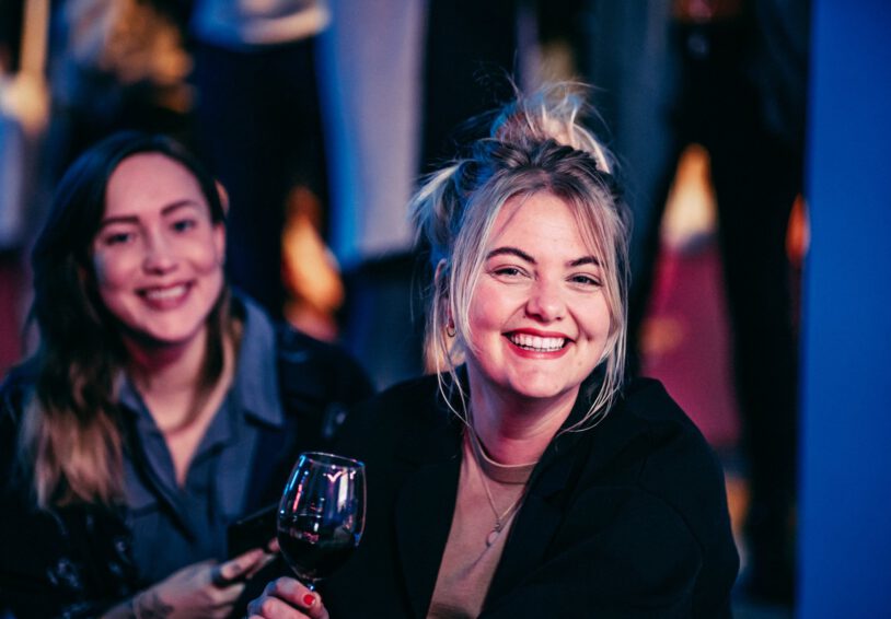 Vrienden van Rutgers op de borrel, twee vrouwen lachen blij in de camera.