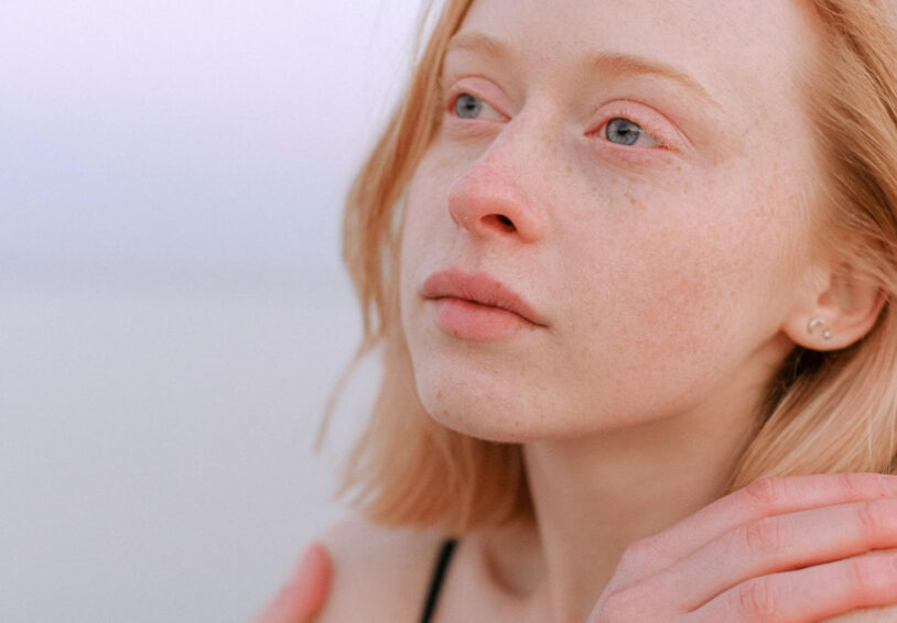 Jonge vrouw met rood haar en blauwe ogen